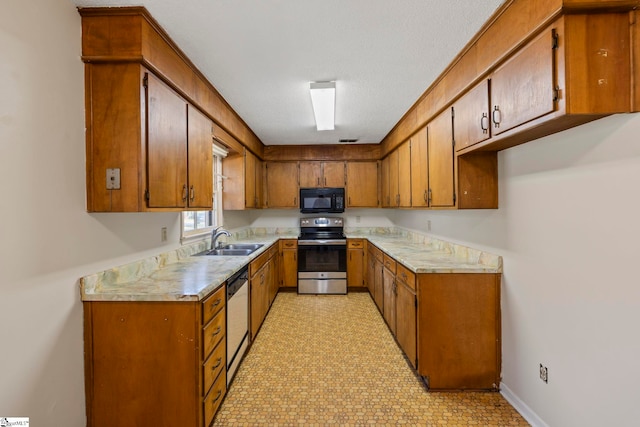 kitchen featuring a textured ceiling, sink, and stainless steel appliances