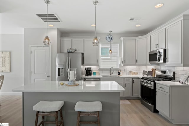 kitchen featuring pendant lighting, a center island, sink, and stainless steel appliances