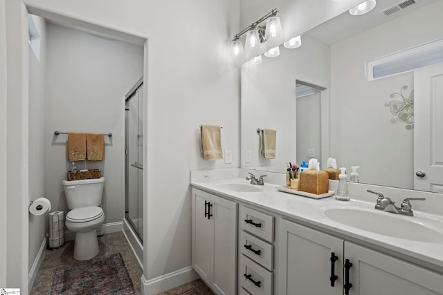 bathroom with vanity, toilet, and a shower with shower door