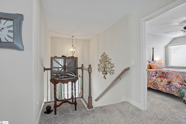 hallway featuring carpet flooring and a chandelier