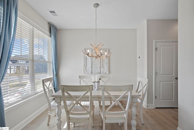 dining room featuring light hardwood / wood-style floors and an inviting chandelier