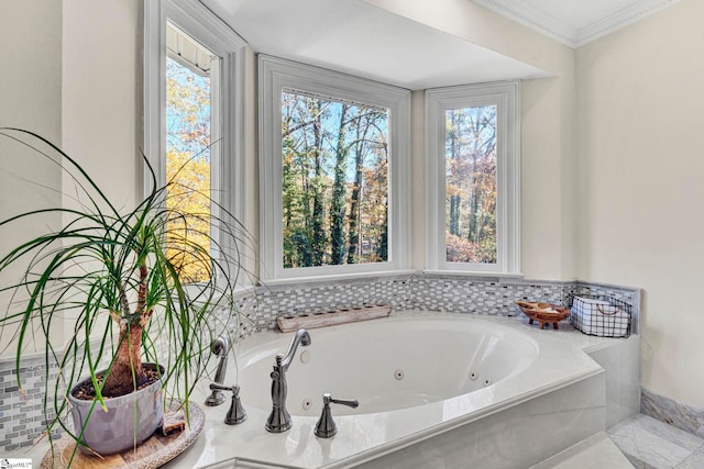 bathroom with plenty of natural light, ornamental molding, and tiled tub