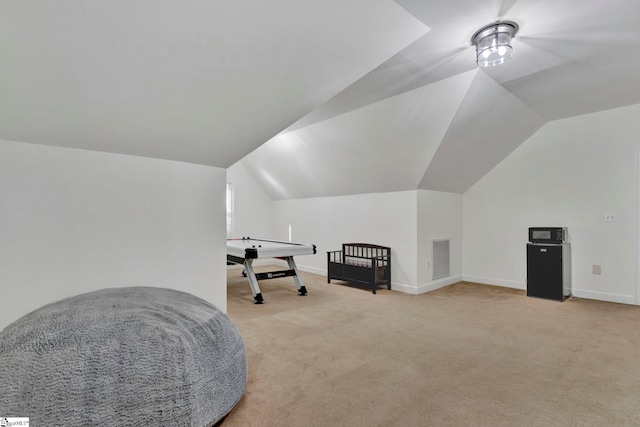 living area featuring light colored carpet and vaulted ceiling