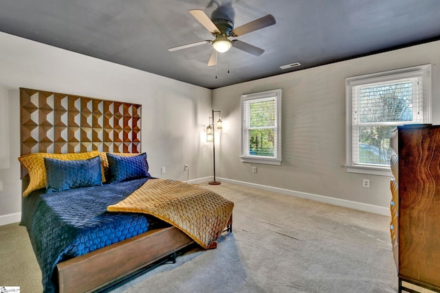 carpeted bedroom with ceiling fan and multiple windows