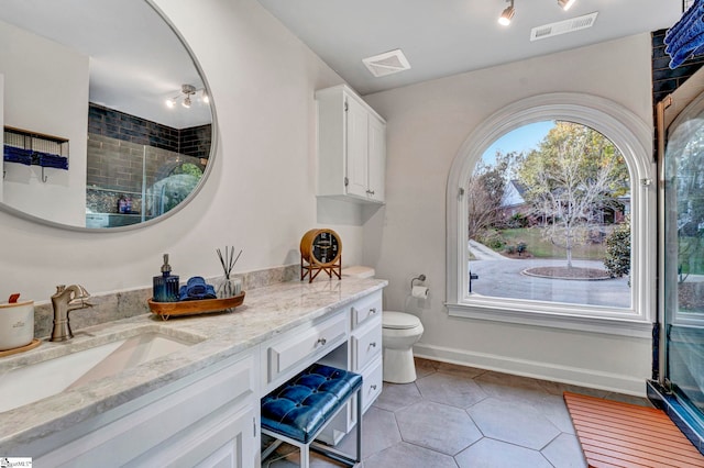 bathroom with tile patterned floors, vanity, toilet, and a shower with shower door