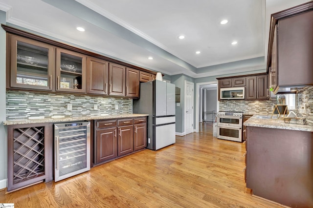 kitchen featuring wine cooler, dark brown cabinets, stainless steel appliances, and light hardwood / wood-style floors