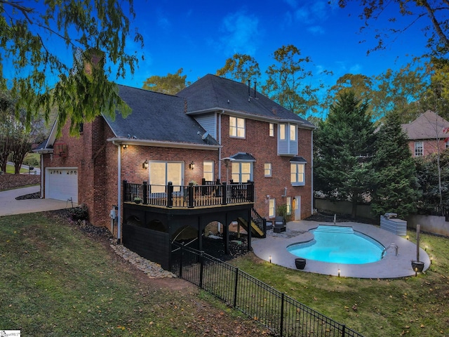 pool at dusk featuring a deck and a lawn