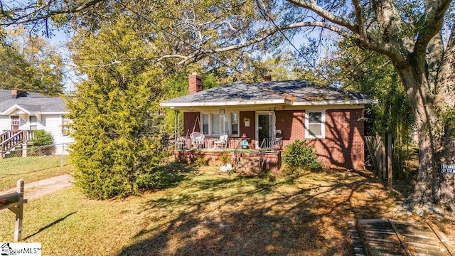 view of front of house with covered porch and a front lawn