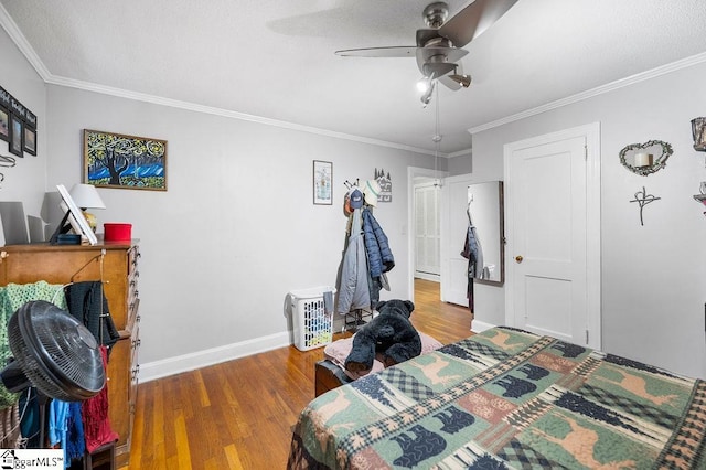 bedroom with hardwood / wood-style floors, ceiling fan, and crown molding