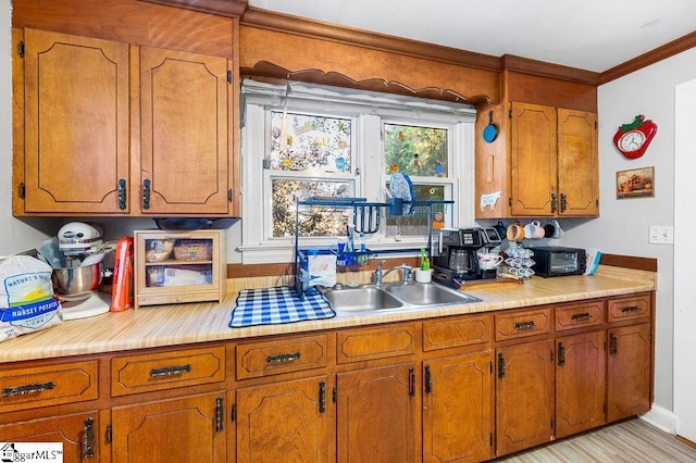 kitchen with light wood-type flooring and crown molding