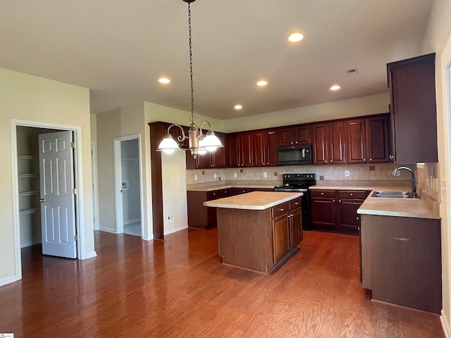 kitchen featuring a center island, dark wood-type flooring, black appliances, sink, and decorative light fixtures