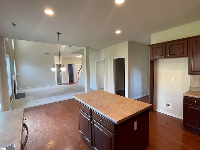 kitchen with an inviting chandelier, decorative light fixtures, a kitchen island, dark hardwood / wood-style flooring, and dark brown cabinetry