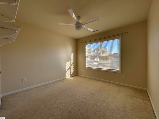 spare room featuring ceiling fan and light colored carpet