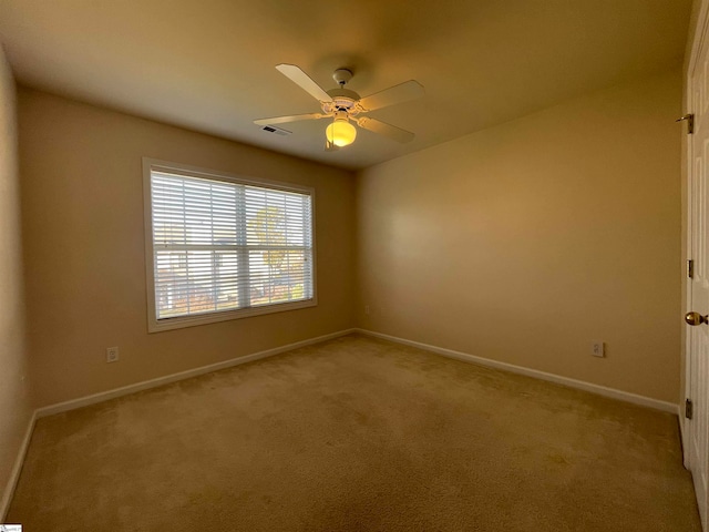 unfurnished room with ceiling fan and light carpet