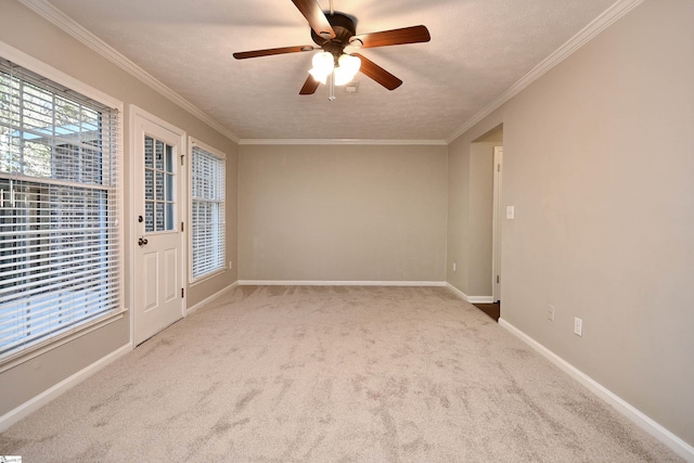 carpeted empty room featuring ceiling fan, ornamental molding, and a textured ceiling