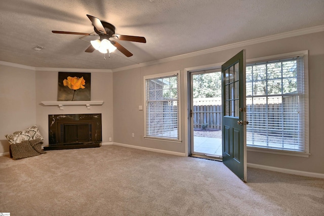 unfurnished living room with carpet, a textured ceiling, ceiling fan, and ornamental molding