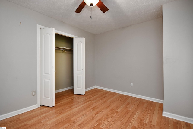 unfurnished bedroom with a closet, a textured ceiling, light hardwood / wood-style floors, and ceiling fan