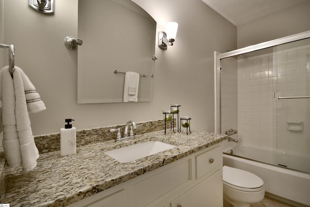 full bathroom with vanity, toilet, and enclosed tub / shower combo