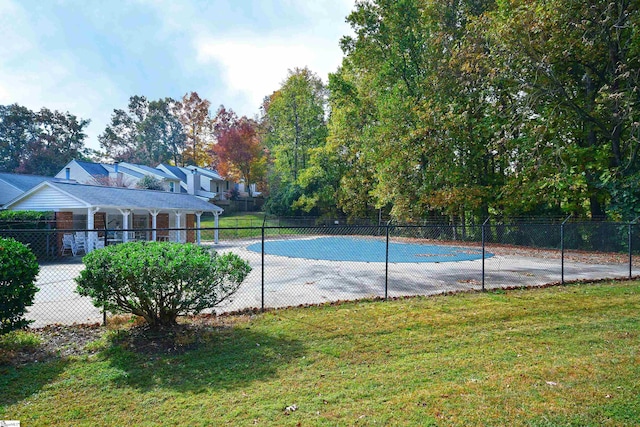 view of swimming pool featuring a lawn and tennis court