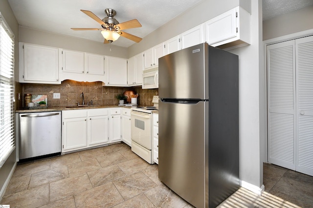 kitchen with backsplash, white cabinets, sink, ceiling fan, and appliances with stainless steel finishes