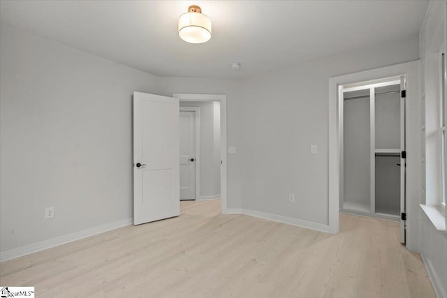 unfurnished bedroom featuring light wood-type flooring and a closet