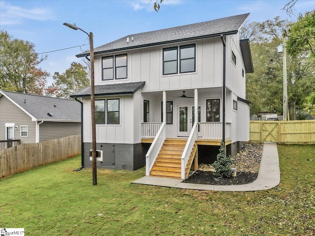 rear view of property featuring a yard and ceiling fan