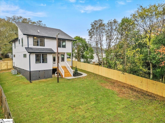 back of house with a yard and central AC