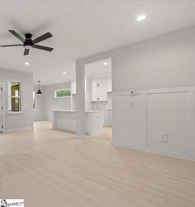 unfurnished living room with light hardwood / wood-style floors and ceiling fan