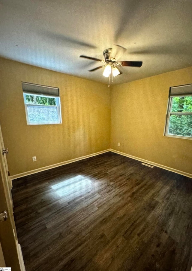 empty room featuring ceiling fan and dark hardwood / wood-style flooring