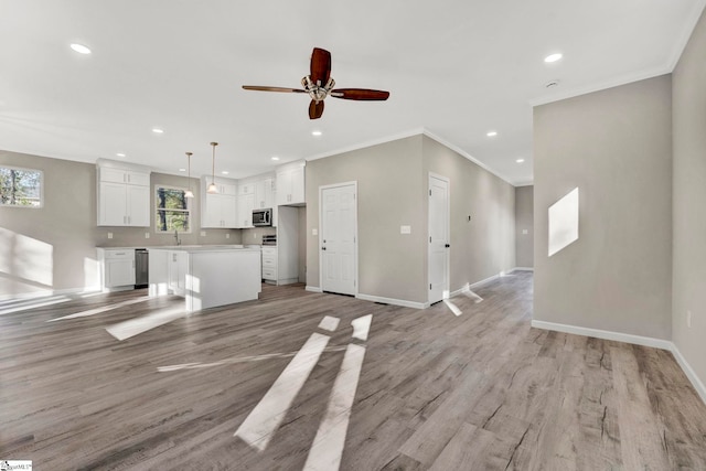 unfurnished living room with ceiling fan, light hardwood / wood-style floors, sink, and crown molding