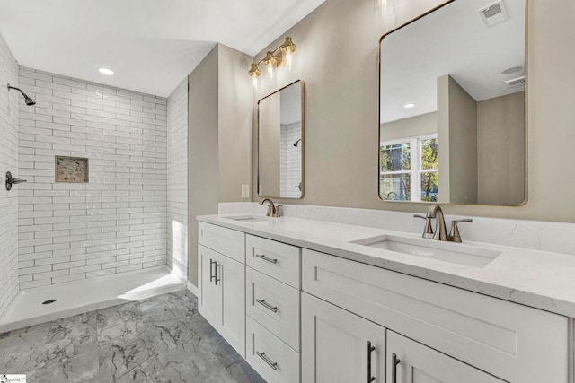 bathroom featuring a tile shower and vanity