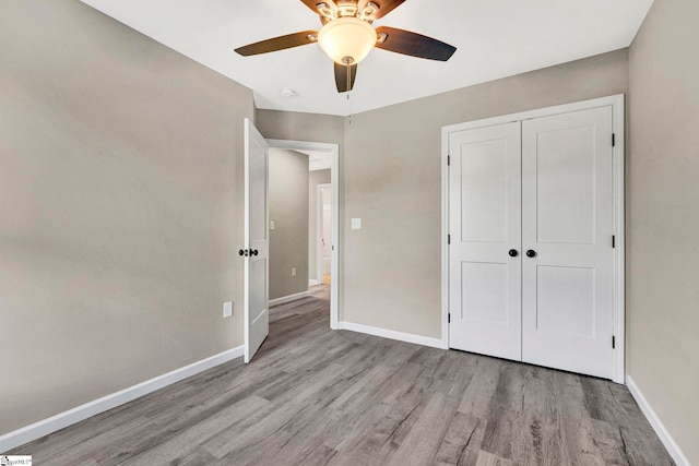 unfurnished bedroom with light wood-type flooring, a closet, and ceiling fan