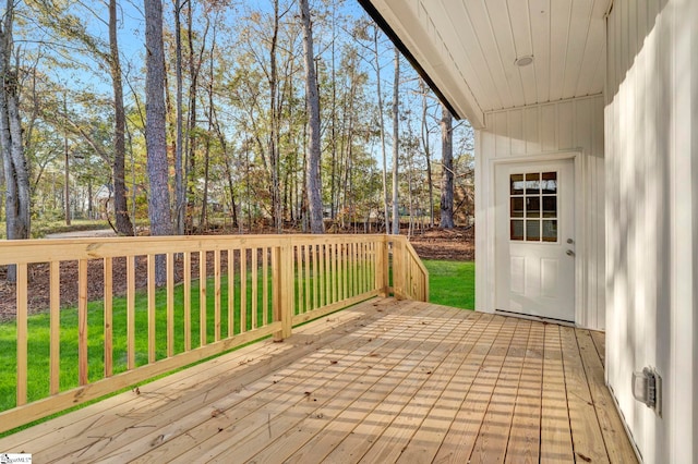 wooden terrace featuring a yard