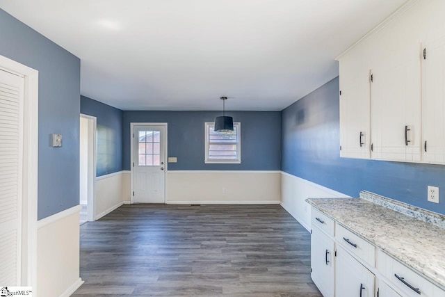 kitchen featuring dark hardwood / wood-style flooring, white cabinets, and decorative light fixtures