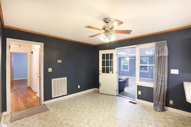 interior space featuring ceiling fan, light hardwood / wood-style floors, wood walls, and ornamental molding