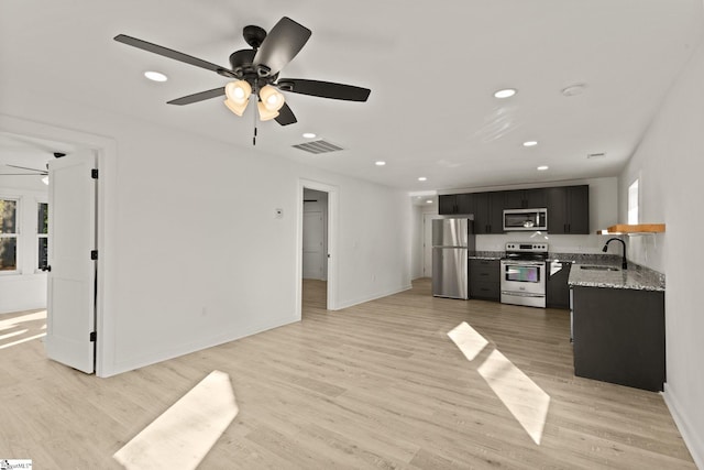 kitchen with ceiling fan, sink, stainless steel appliances, and light hardwood / wood-style floors