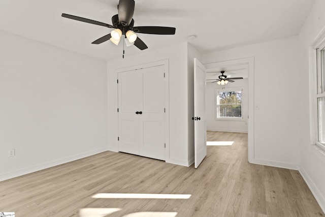 unfurnished bedroom featuring ceiling fan, light hardwood / wood-style floors, and a closet