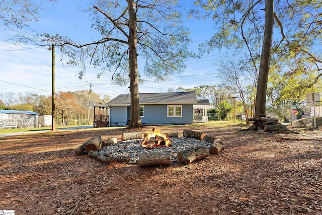 back of property with an outdoor fire pit