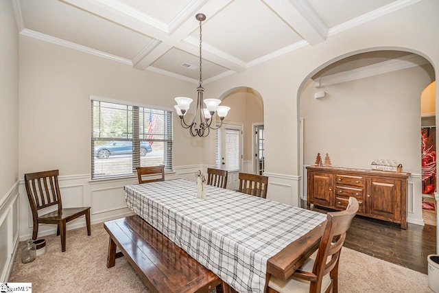 dining area with beamed ceiling, dark hardwood / wood-style flooring, a chandelier, coffered ceiling, and crown molding