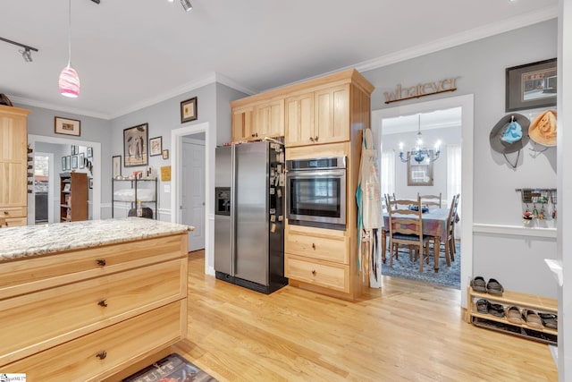 kitchen with light hardwood / wood-style floors, hanging light fixtures, and appliances with stainless steel finishes