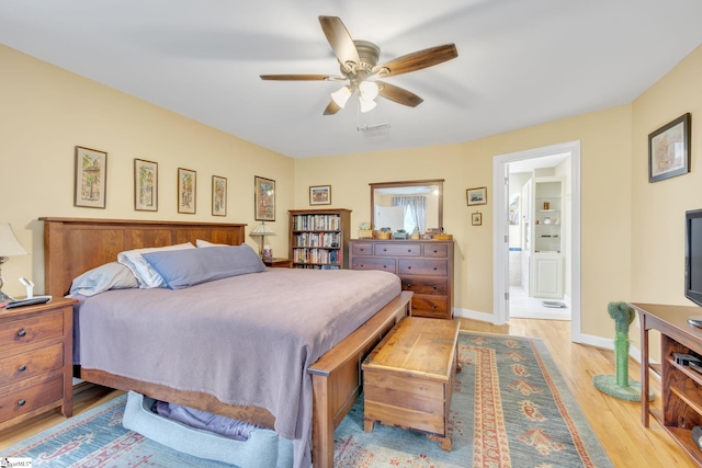 bedroom featuring ceiling fan, light wood-type flooring, and ensuite bath