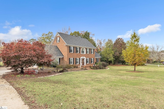 colonial-style house featuring a front lawn