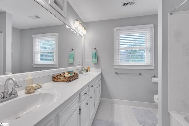 bathroom featuring tile patterned floors, vanity, a healthy amount of sunlight, and toilet