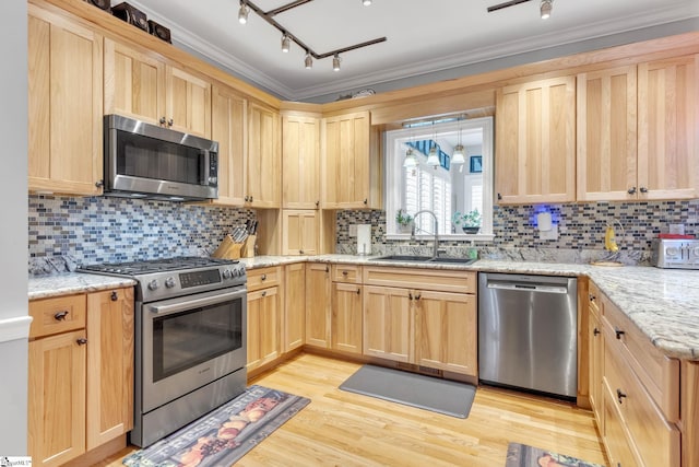 kitchen featuring decorative backsplash, sink, ornamental molding, and stainless steel appliances