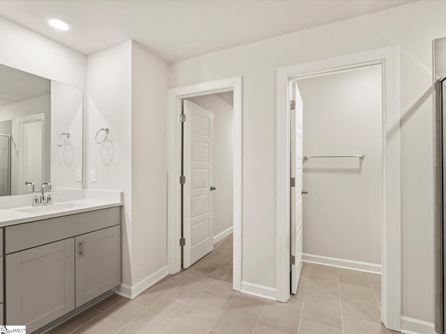 bathroom featuring vanity, a shower with shower door, and tile patterned flooring