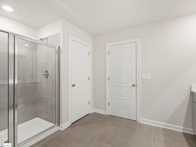 bathroom with tile patterned flooring, vanity, and a shower with shower door