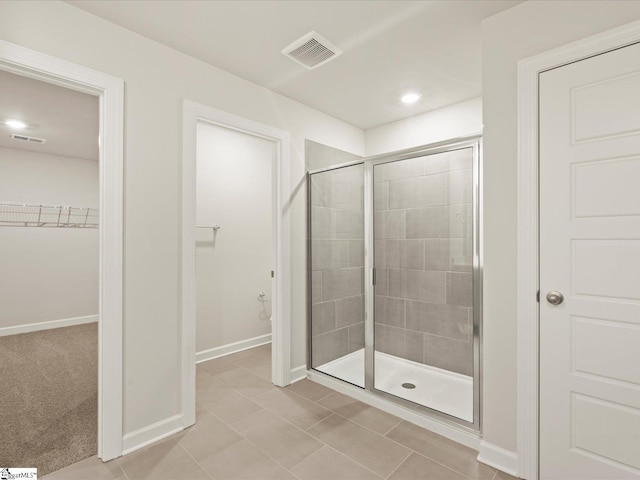 bathroom featuring a shower with door and tile patterned flooring