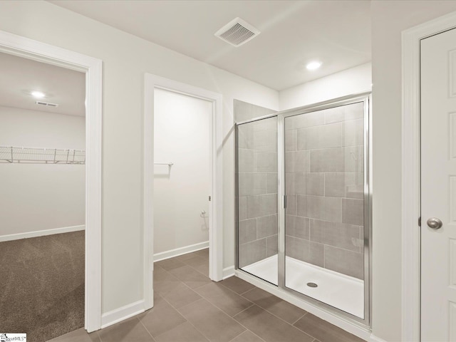 bathroom with tile patterned flooring and a shower with shower door