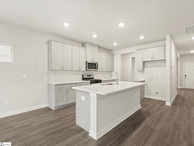 kitchen with sink, dark wood-type flooring, a center island with sink, and appliances with stainless steel finishes