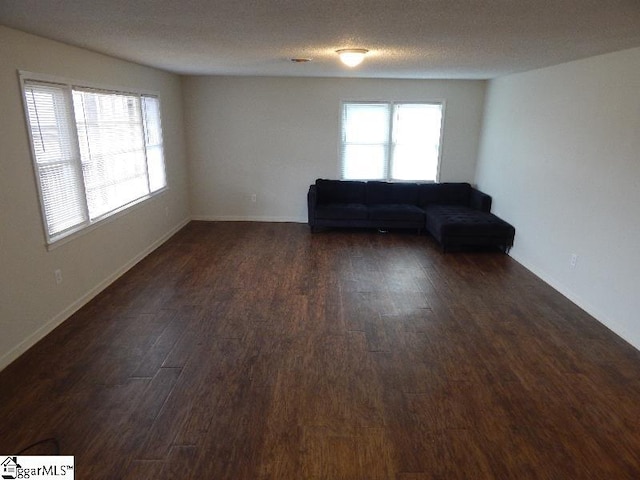 interior space featuring a textured ceiling and dark wood-type flooring